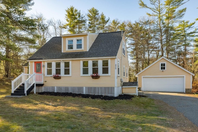 view of front of house with an outbuilding, a garage, and a front lawn