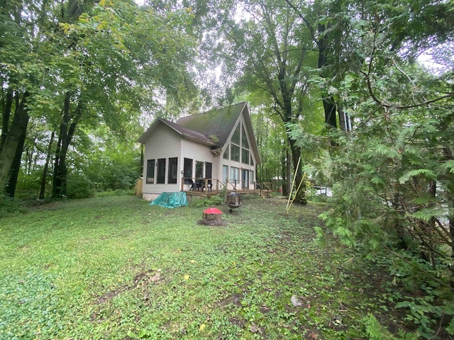 back of house with a deck and a lawn