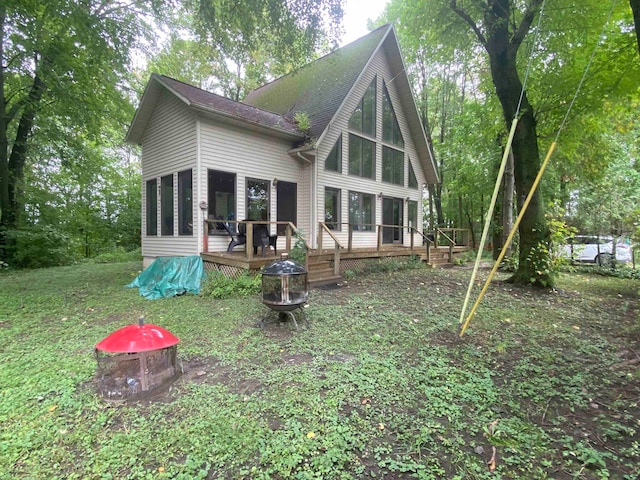 back of property with an outdoor fire pit and a wooden deck