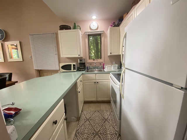 kitchen with white cabinetry, sink, kitchen peninsula, white appliances, and light tile patterned flooring