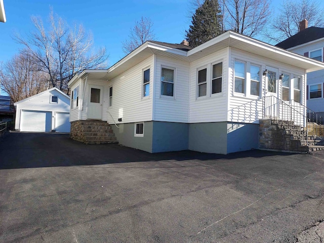 view of side of home with an outdoor structure and a garage