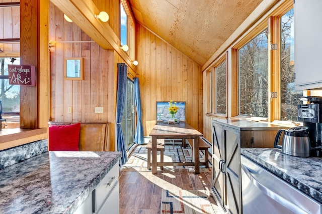 interior space with white cabinetry, wooden walls, dark hardwood / wood-style floors, and vaulted ceiling