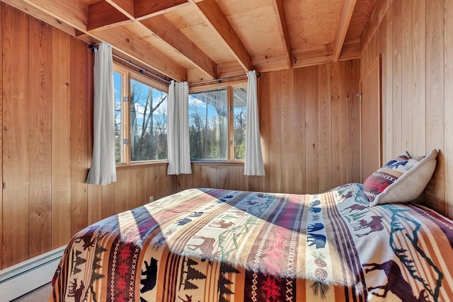 bedroom featuring multiple windows, a baseboard heating unit, and wood walls