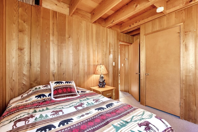 carpeted bedroom with beam ceiling and wooden walls