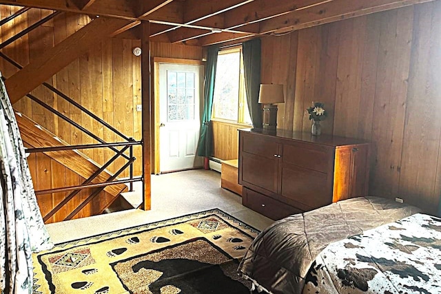 carpeted bedroom featuring baseboard heating and wooden walls