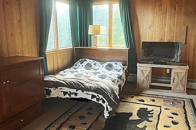 bedroom featuring a baseboard heating unit and wood walls