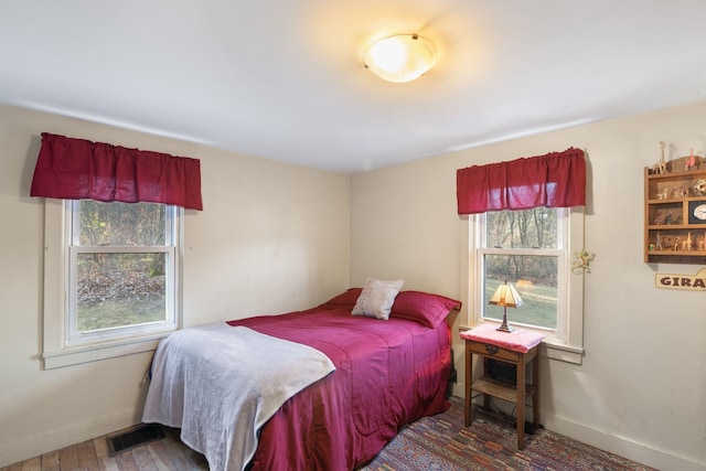 bedroom featuring wood-type flooring and multiple windows