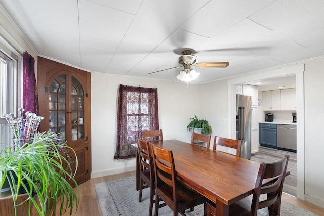 dining space with ceiling fan and light wood-type flooring