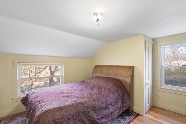 bedroom with vaulted ceiling, a closet, and light wood-type flooring