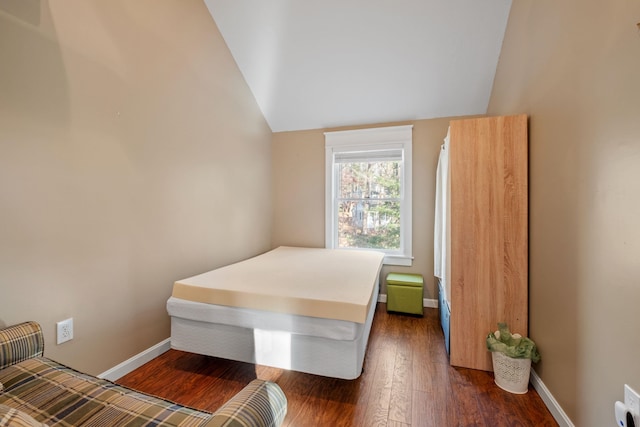 bedroom with dark hardwood / wood-style floors and lofted ceiling