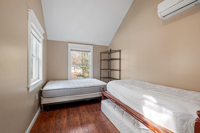 bedroom with a wall unit AC, dark wood-type flooring, and vaulted ceiling