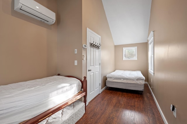 bedroom with vaulted ceiling, a wall unit AC, and dark wood-type flooring