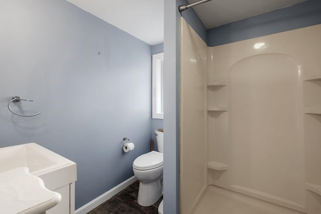 bathroom featuring a shower, wood-type flooring, vanity, and toilet