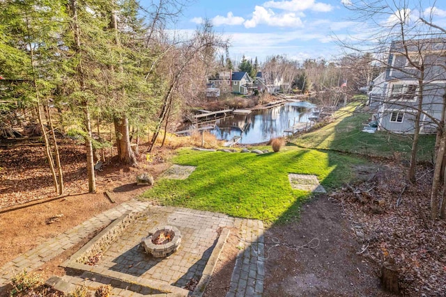 view of yard featuring a patio area, an outdoor fire pit, and a water view