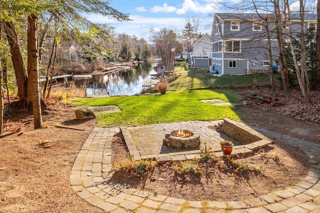 view of yard with a fire pit, a patio area, and a water view