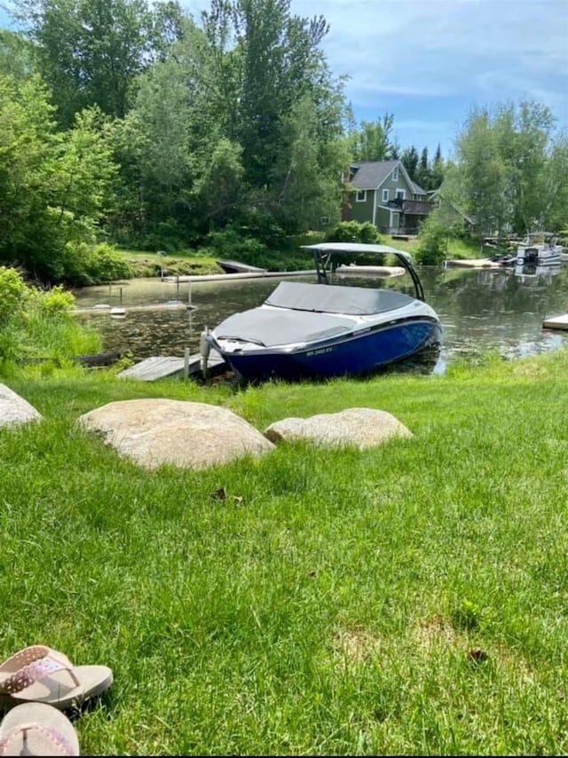 view of property's community with a yard and a water view