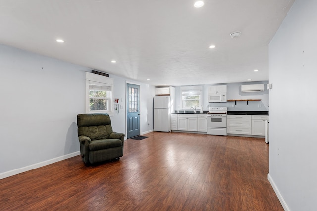 interior space featuring a wall mounted air conditioner, dark wood-type flooring, and sink