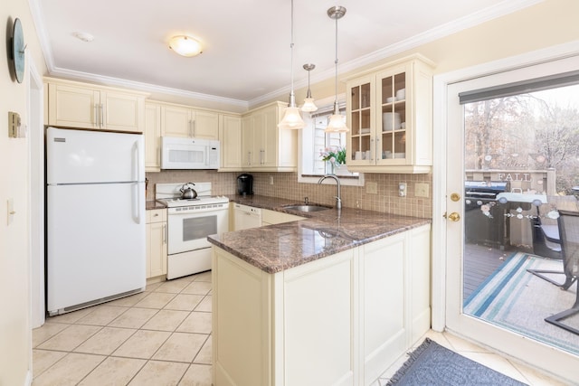 kitchen featuring pendant lighting, white appliances, sink, dark stone countertops, and kitchen peninsula