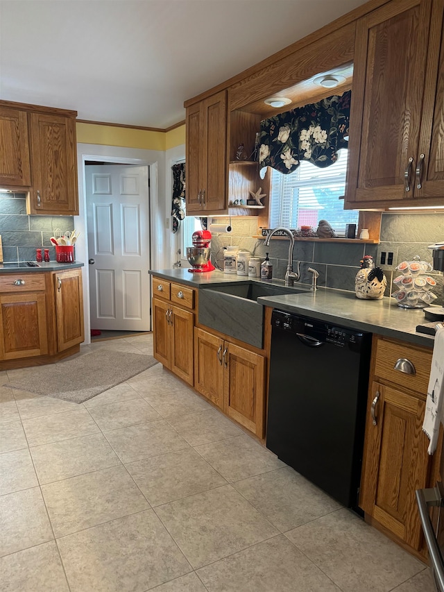 kitchen featuring backsplash, sink, light tile patterned floors, and black dishwasher