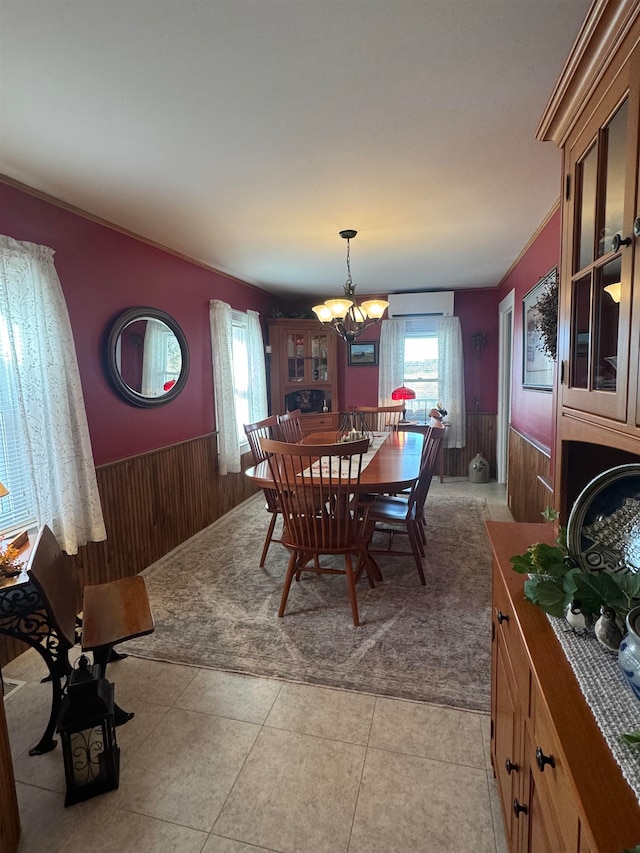 tiled dining area with a chandelier, a wall unit AC, and wooden walls