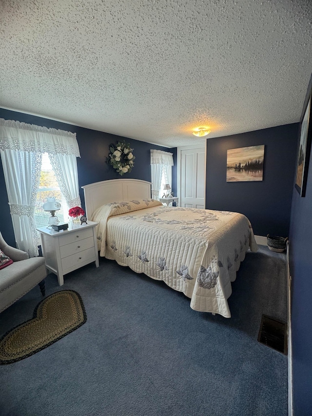 carpeted bedroom with a textured ceiling and multiple windows