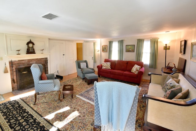 living room with hardwood / wood-style floors and a brick fireplace