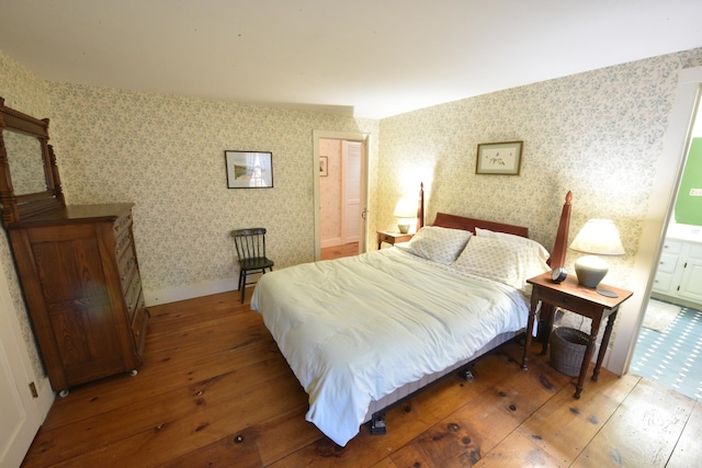 bedroom with hardwood / wood-style flooring and ensuite bath