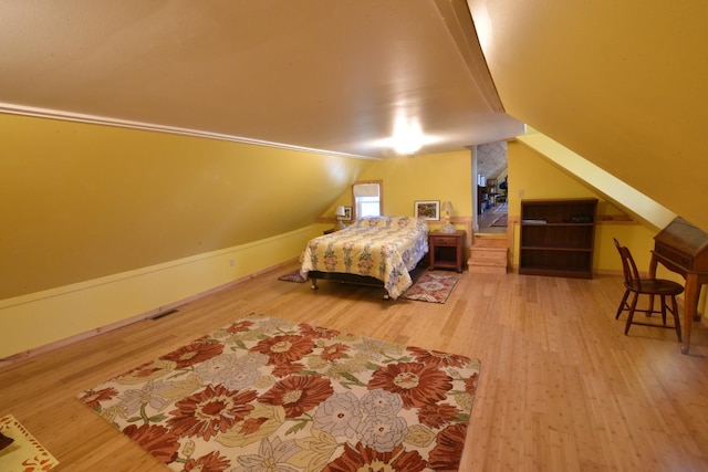 bedroom with lofted ceiling and hardwood / wood-style flooring