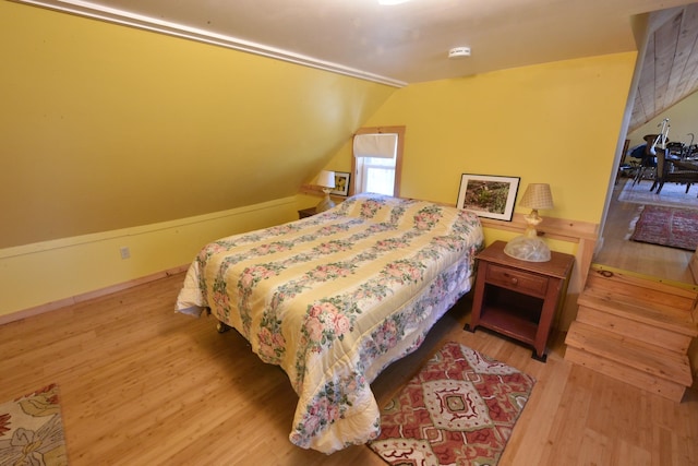 bedroom featuring light hardwood / wood-style flooring and vaulted ceiling