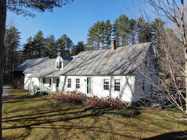 back of house featuring solar panels and a lawn