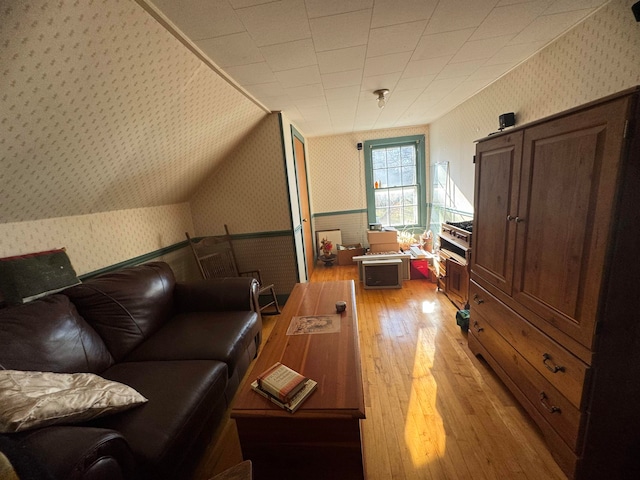 additional living space with light hardwood / wood-style floors and lofted ceiling