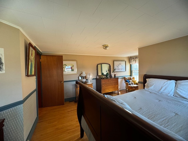 bedroom with hardwood / wood-style floors and ornamental molding