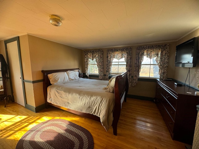 bedroom with crown molding and light hardwood / wood-style flooring