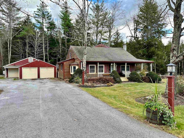 ranch-style house with covered porch, a garage, an outdoor structure, and a front lawn