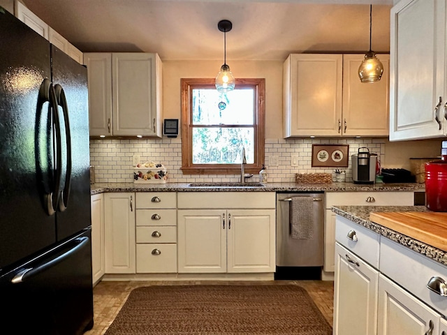 kitchen with black fridge, sink, white cabinets, and decorative light fixtures