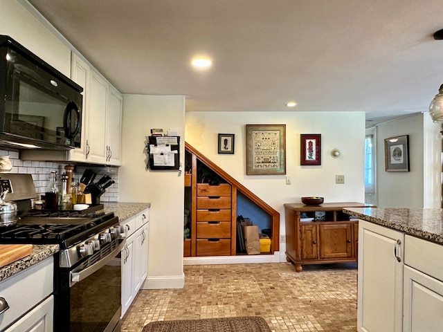 kitchen with gas stove, backsplash, white cabinetry, and light stone counters