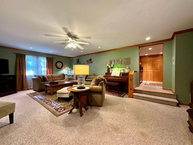 carpeted living room with ceiling fan and ornamental molding