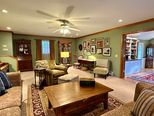 living room featuring ceiling fan, carpet floors, crown molding, and a baseboard radiator