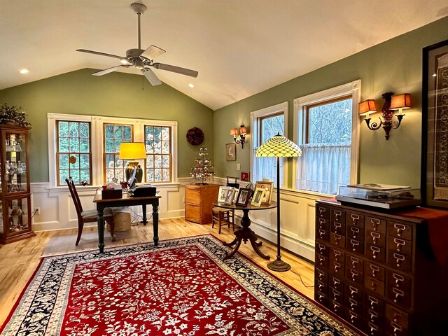 office space with a healthy amount of sunlight, lofted ceiling, and light hardwood / wood-style flooring