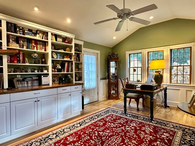 home office with ceiling fan, lofted ceiling, and light wood-type flooring