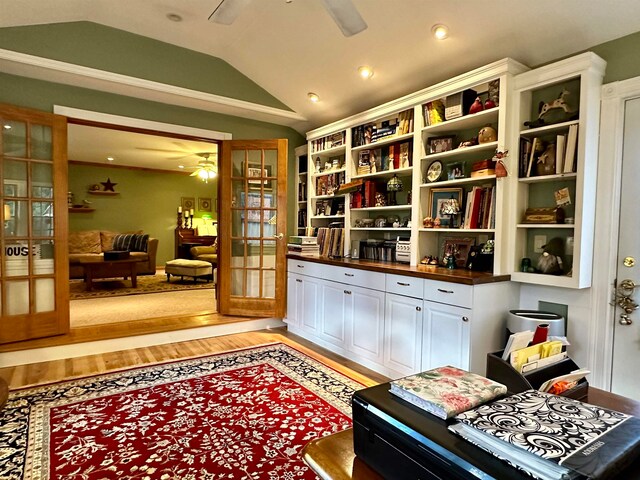 living area featuring french doors, light wood-type flooring, vaulted ceiling, and ceiling fan