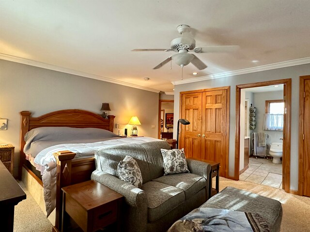 bedroom with ceiling fan, light colored carpet, ornamental molding, and connected bathroom