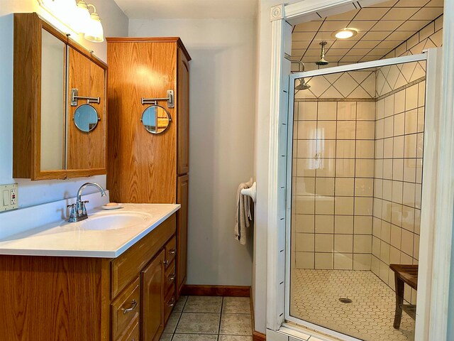 bathroom with tile patterned flooring, vanity, and walk in shower