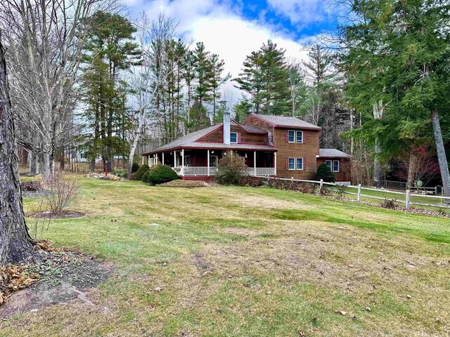 view of front of home with covered porch and a front lawn