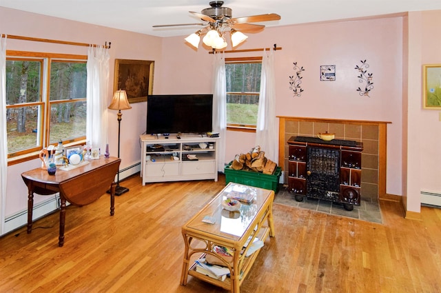 living room with ceiling fan, wood-type flooring, and a baseboard radiator