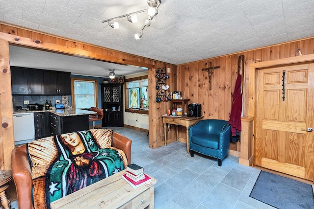 living room featuring ceiling fan and wood walls