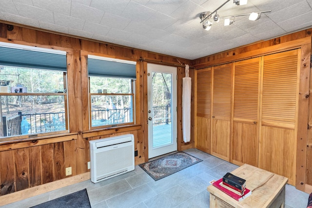 doorway featuring a wall unit AC and wood walls