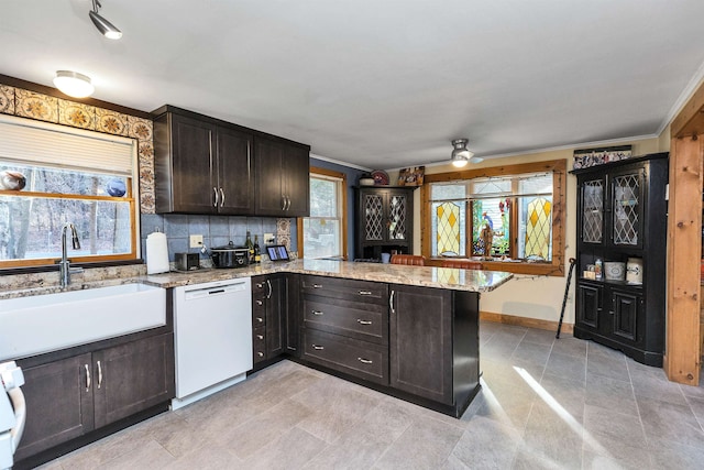 kitchen featuring kitchen peninsula, dishwasher, a healthy amount of sunlight, and sink