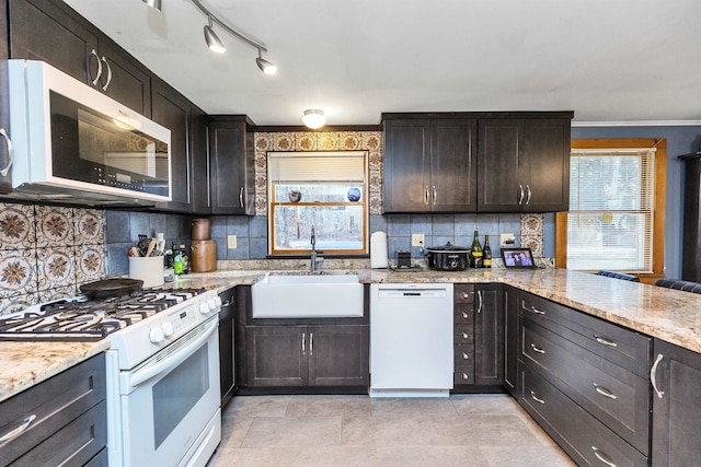 kitchen featuring decorative backsplash, dark brown cabinets, white appliances, and sink