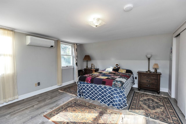 bedroom with hardwood / wood-style floors, lofted ceiling, and a wall mounted AC